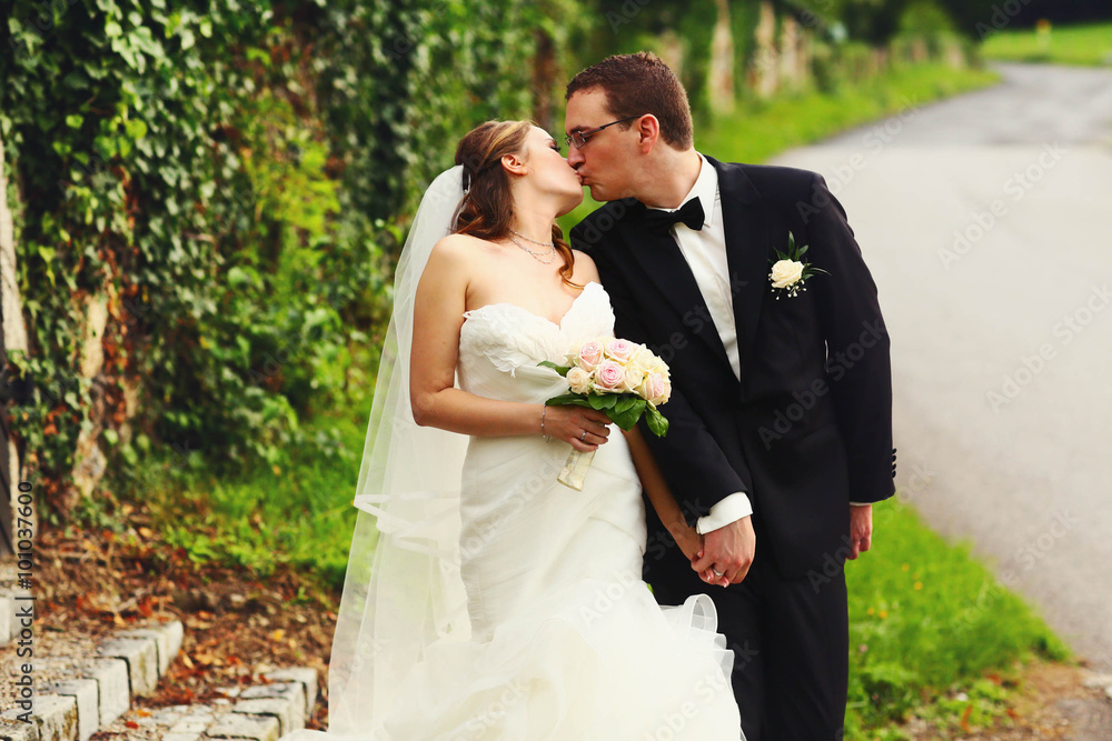gentle stylish couple on the background green ivy wall, road, d gentle stylish couple on the background green ivy wall, road, d