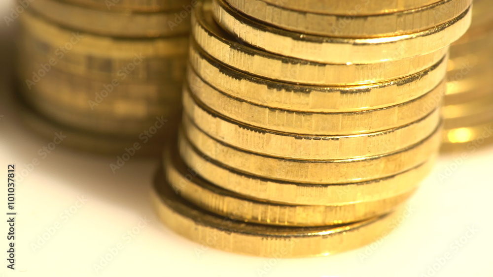 Macro view of shining golden edges of coins in piles turning slowly Macro view of shining golden edges of coins in piles turning slowly