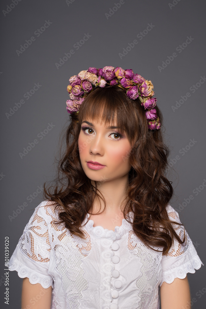beautiful woman portrait with wreath of flowers studio shot