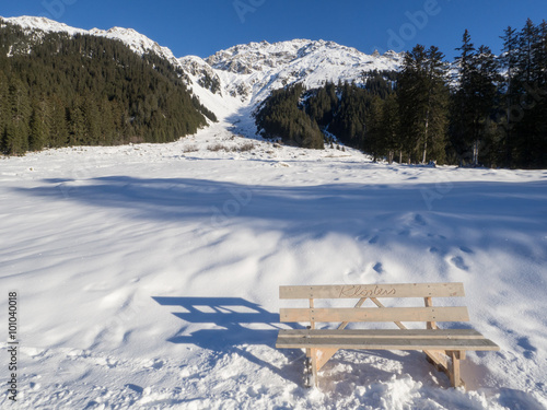 A view of bench in front of snow - covered landscape in Klosters.