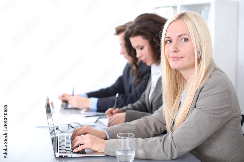A group of business people at a meeting on the background of office. Focus on a beautiful blonde A group of business people at a meeting on the background of office. Focus on a beautiful blonde
