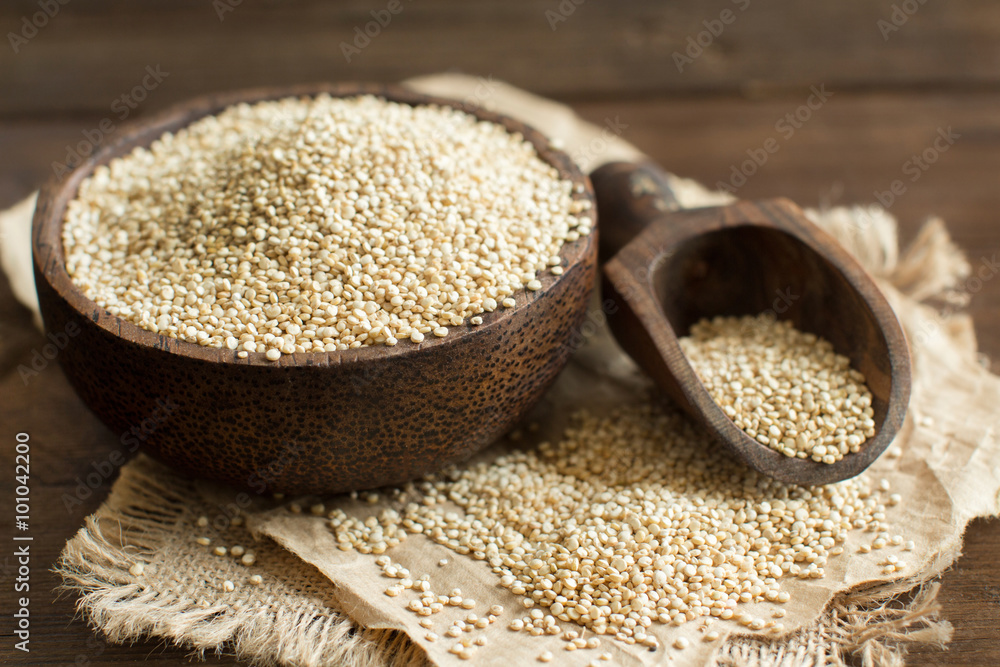 White Quinoa in a bowl with a wooden spoon White Quinoa in a bowl with a wooden spoon
