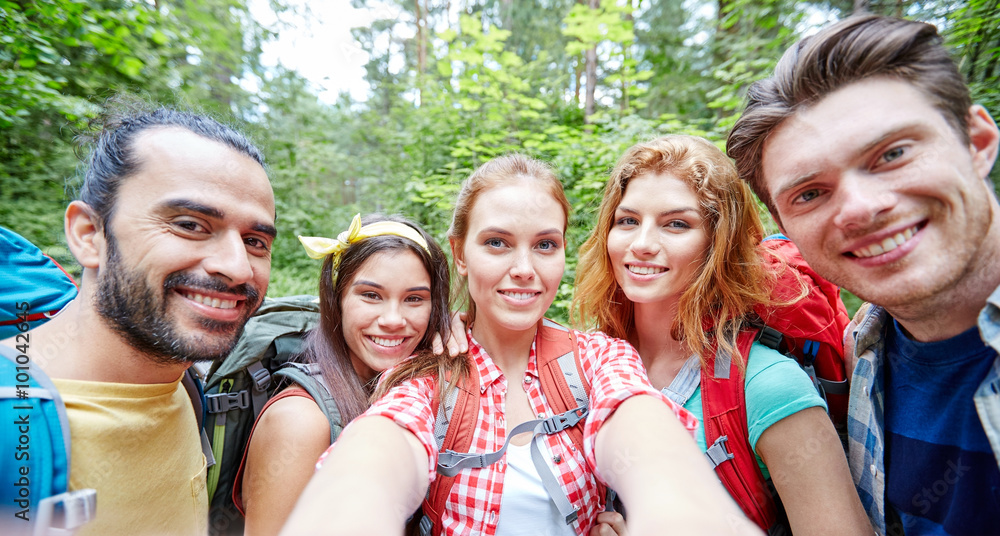 Obraz premium friends with backpack taking selfie in wood
