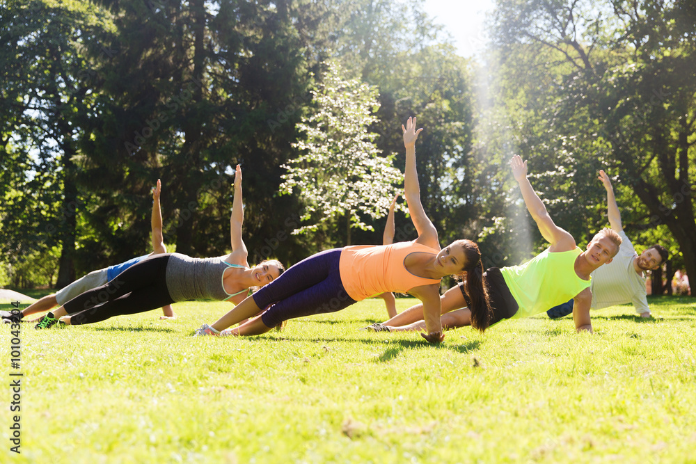 group of happy friends exercising outdoors
