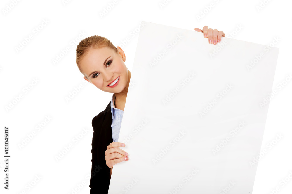 Smiling young businesswoman holding blank banner Smiling young businesswoman holding blank banner