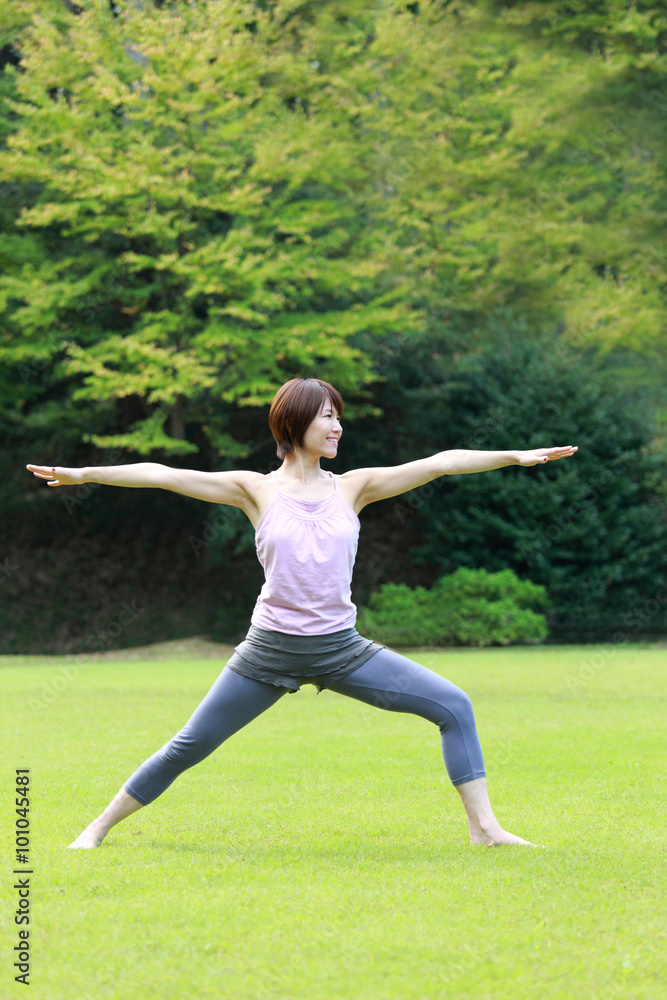 Japanese woman doing yoga warrior II pose Japanese woman doing yoga warrior II pose