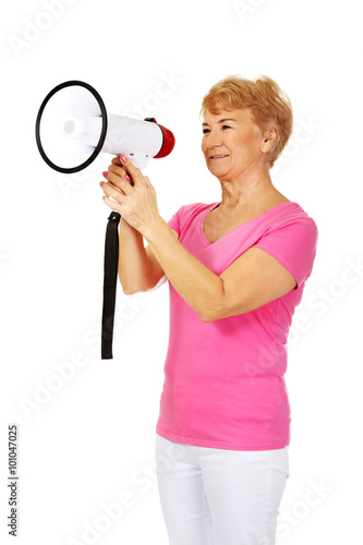 Senior smiling woman screaming through a megaphone