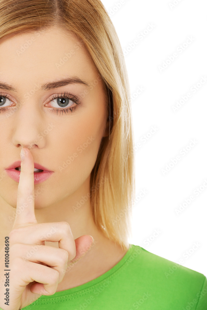 Naklejka premium Young woman with finger on lips