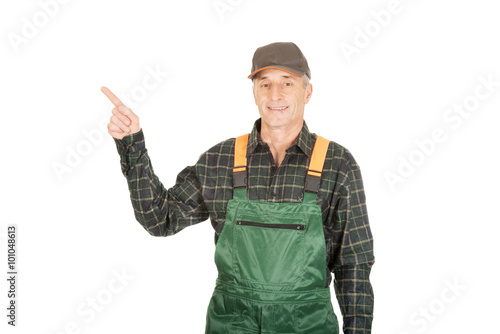 Mature gardener in uniform pointing up