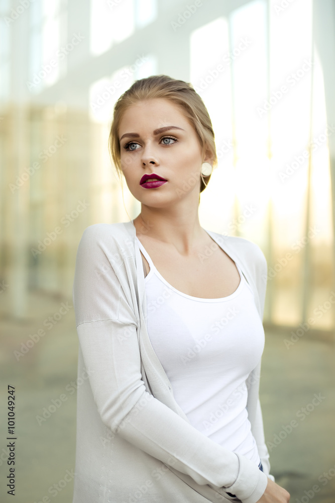 Young fashion blond business woman against a mall window