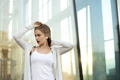 blonde with burgundy lipstick near the glass of a modern building