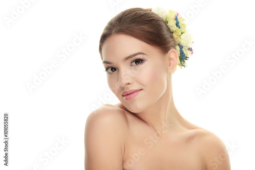 Beauty portrait of young cute brunette woman with adorable makeup slightly smite flower headpiece on white studio background