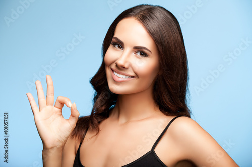 woman showing okay gesture, on bright blue photo