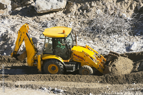  large excavator works carrying debris in highway construction site