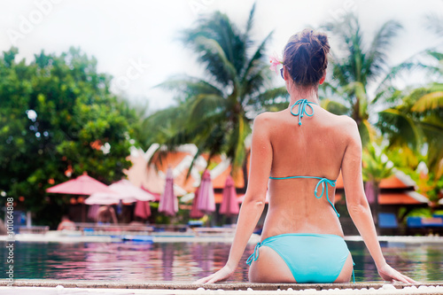 Beautiful young woman in sunglassesand straw hat near luxury pool © el.rudakova