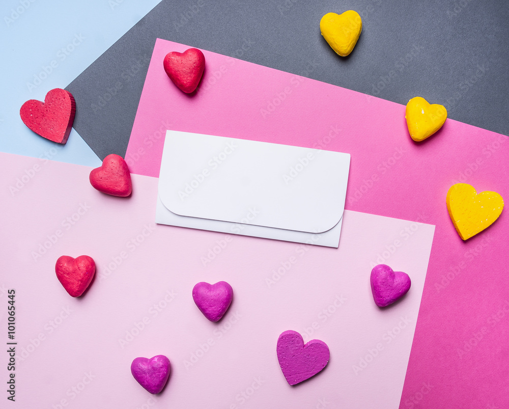 white envelope with colorful hearts around on a colorful background top view close up decorations for Valentine's Day white envelope with colorful hearts around on a colorful background top view close up decorations for Valentine's Day