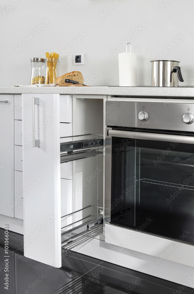 Fototapeta premium Part of modern kitchen with electric stove oven details, drawers