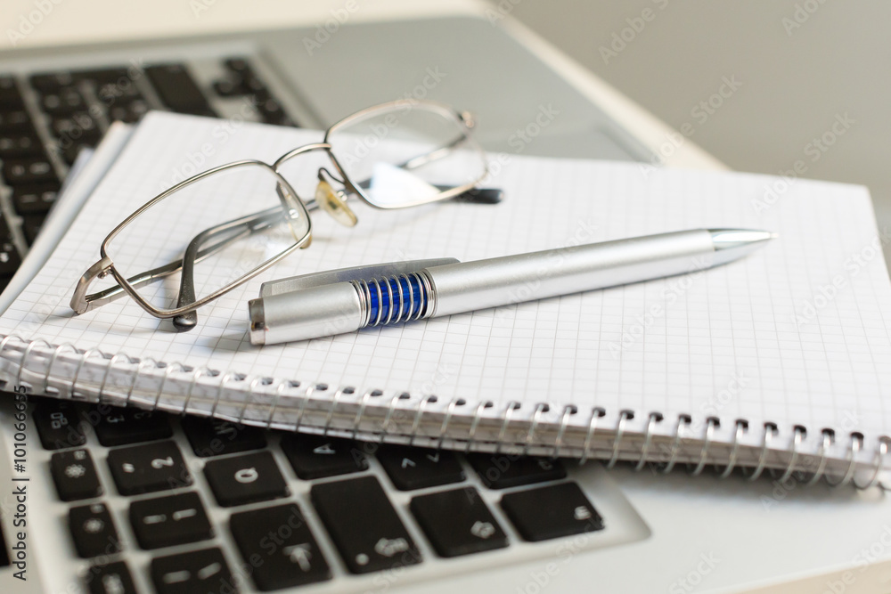 Laptop computer with notepad, pen, glasses and keyboard Laptop computer with notepad, pen, glasses and keyboard