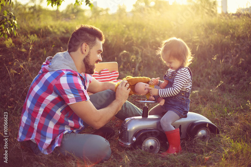 Toddler and father playing with toy in the garden