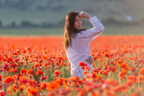Girl at blooming poppy field