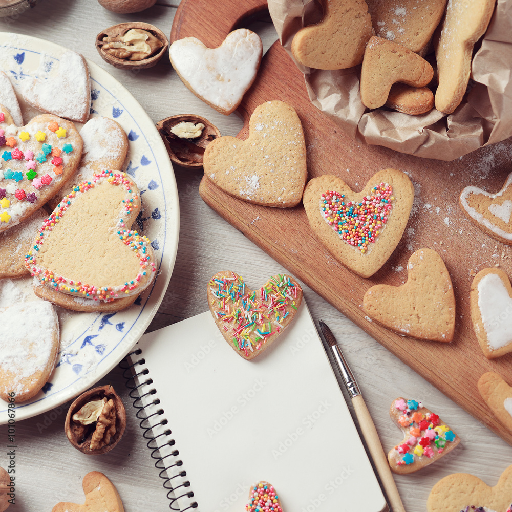 Desk with Valentines cookies with notepad Desk with Valentines cookies with notepad