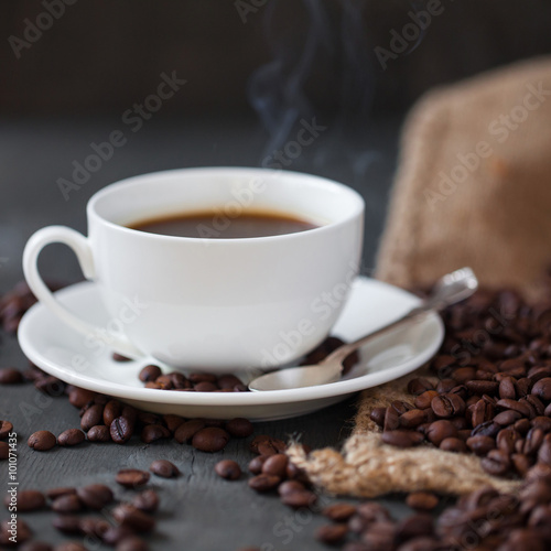 Coffee cup and saucer on a wooden table. Grey background