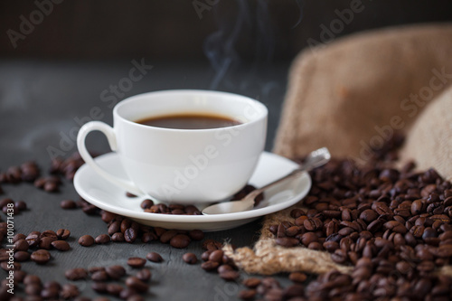 Coffee cup and saucer on a wooden table. Grey background