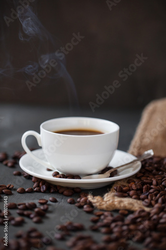 Coffee cup and saucer on a wooden table. Grey background