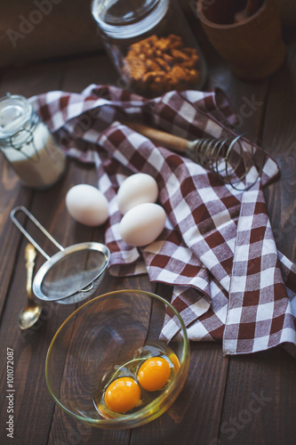 Baking cake ingredients - bowl, flour, eggs, egg whites foam on wooden background . Cooking course or kitchen mess poster concept