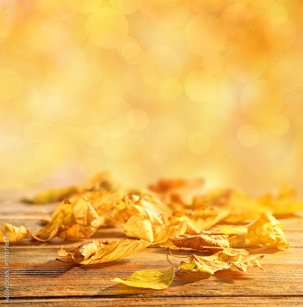 Yellow autumn leaves on wooden table, on nature background Yellow autumn leaves on wooden table, on nature background