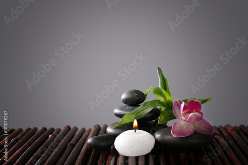 Spa still life with beautiful flower and candlelight on grey background