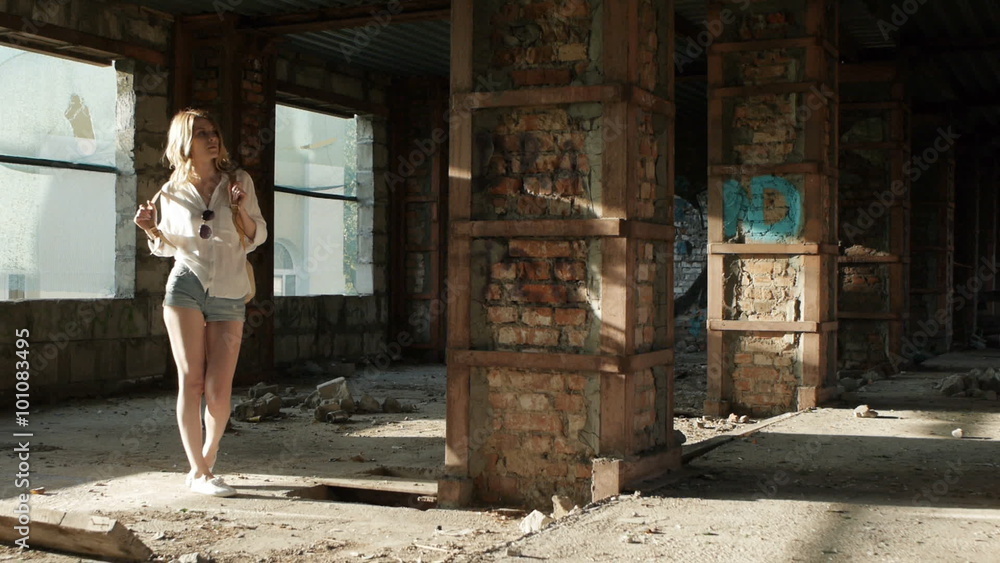 Girl model posing on camera walking through the ruins of an abandoned building. Girl model posing on camera walking through the ruins of an abandoned building.