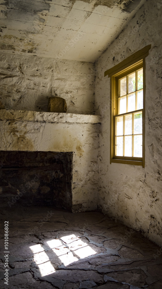 interior of a stone house with light shining through the window.