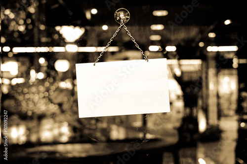 A sign hanging in a shop window with space for text