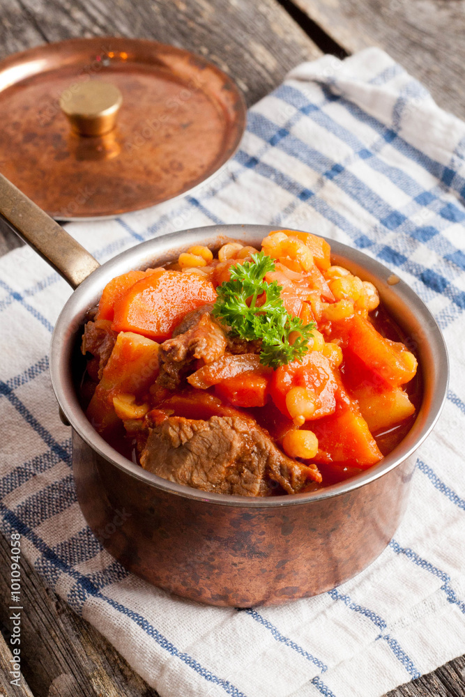 stew of beef with vegetables in a copper pot closeup stew of beef with vegetables in a copper pot closeup