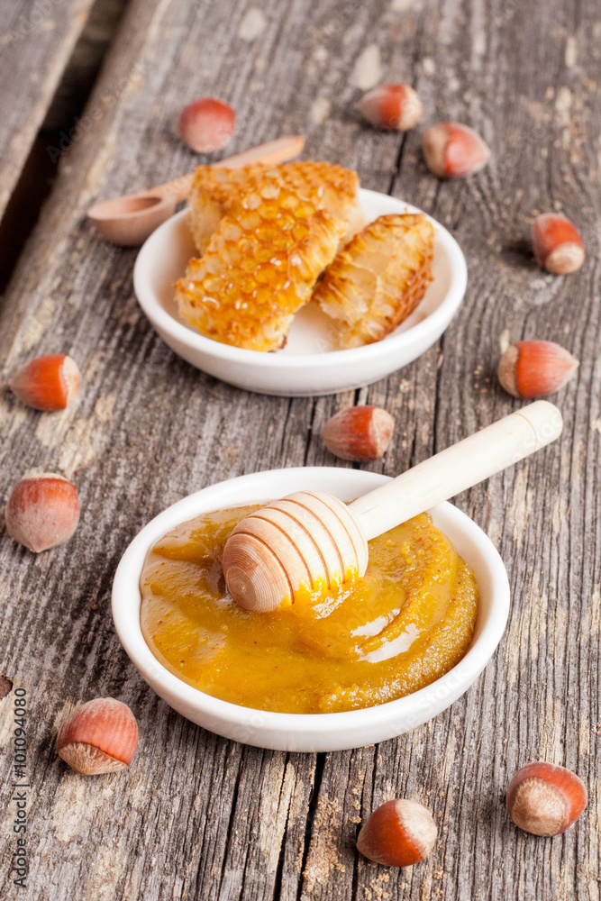 Honey with wooden honey dipper and ceramic bowl honeycomb Honey with wooden honey dipper and ceramic bowl honeycomb