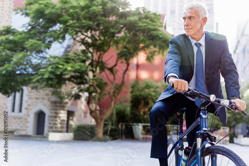 Successful businessman riding bicycle