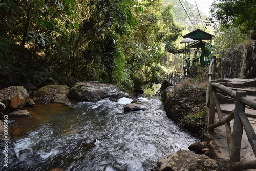 stream flow through the rainforest with the small pathway for ecotourism photo