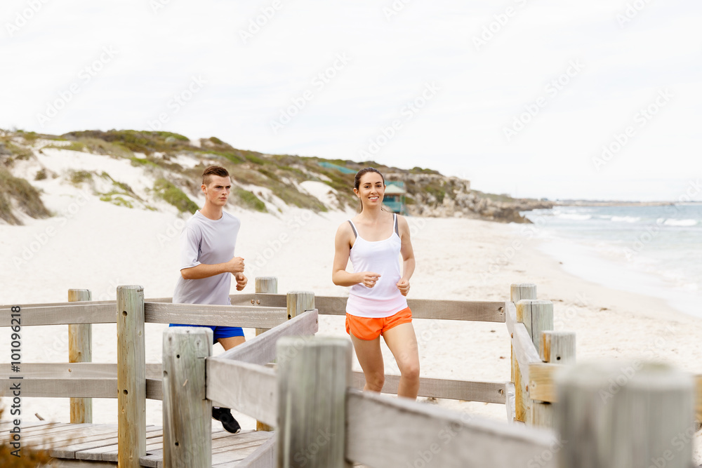 Runners. Young couple running on beach