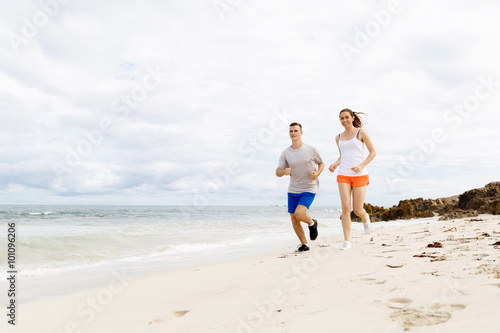 Runners. Young couple running on beach