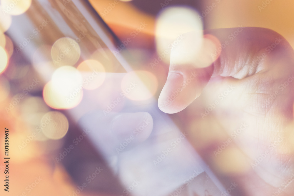 Obraz premium Closeup of an Male fingers touching tablet screen double exposure and defocused city night light background.