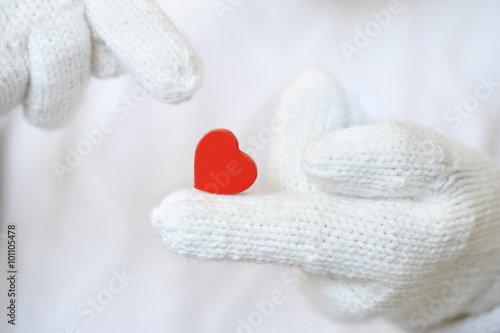 Red heart in white gloves.