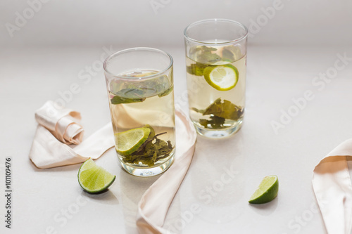 Green tea in a glass with lime and cookies on a plate
