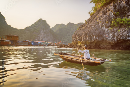 Woman in boat returns to fishing village in the Ha Long Bay