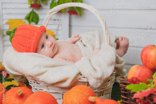 baby in the basket with pumpkins. autumn photo