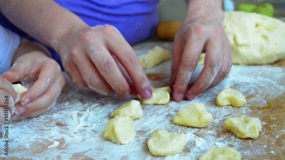 Mother and son playing with the dough with their hands on the table
Mother and son playing with the dough with their hands on the table