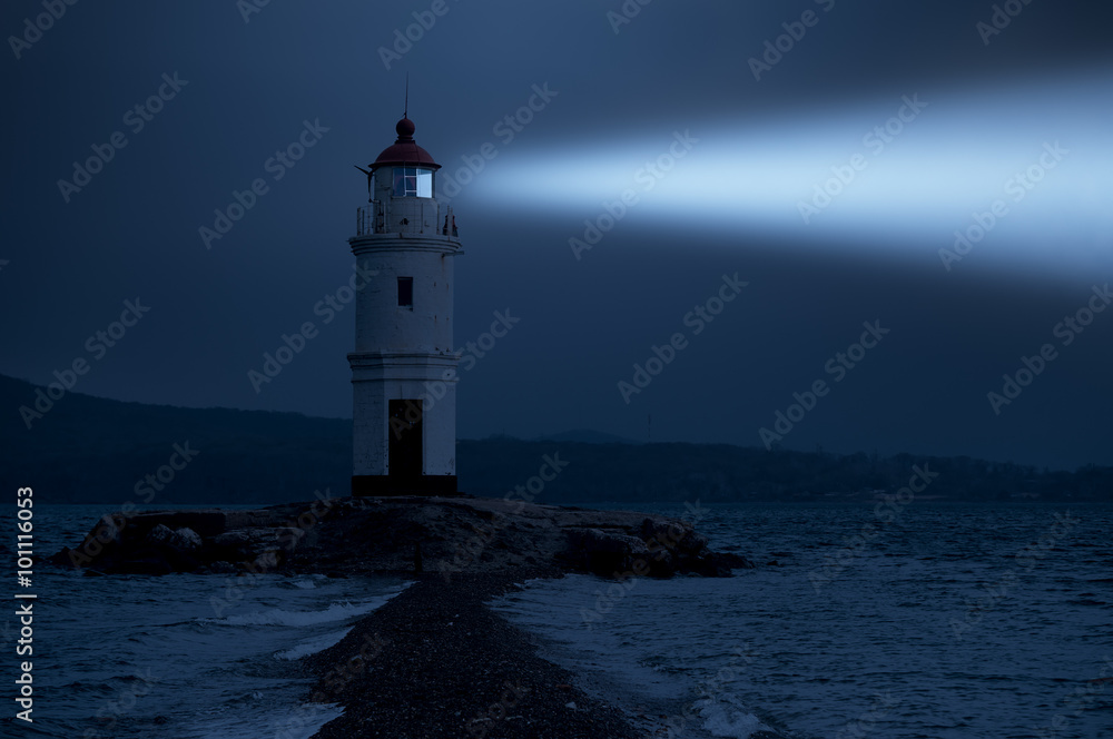 Lighthouse in Vladivostok shines at night in the sea