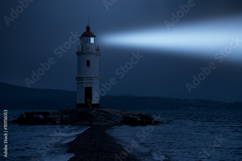Obraz na plátně Lighthouse in Vladivostok shines at night in the sea