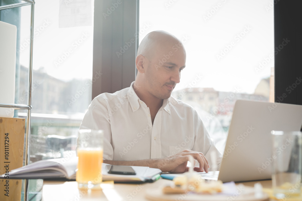 Half length of young handsome caucasian bald business man sittin Half length of young handsome caucasian bald business man sittin