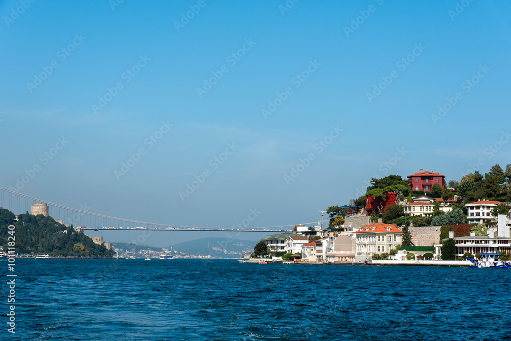 The Bosphorus in Istanbul with a houses at the shore and the second Bosphorus Bridge in the distance